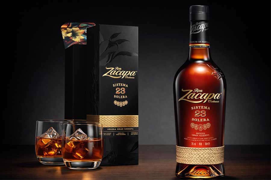 Botella de Ron Zacapa 23, estuche y vasos con hielo.